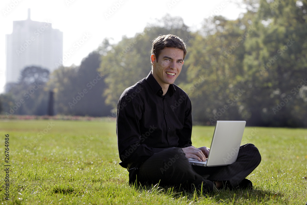 young man inthe park with laptop young man inthe park with laptop