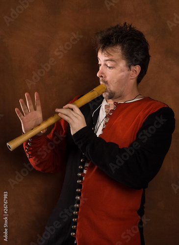 Canvas-taulu Man in a medieval suit plays a flute