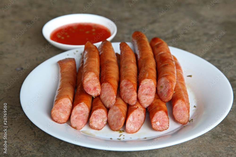 Appetizing grilled sausages with chili sauce in white plate Appetizing grilled sausages with chili sauce in white plate