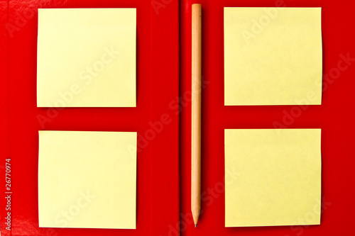 yellow note and pencil on red notebook