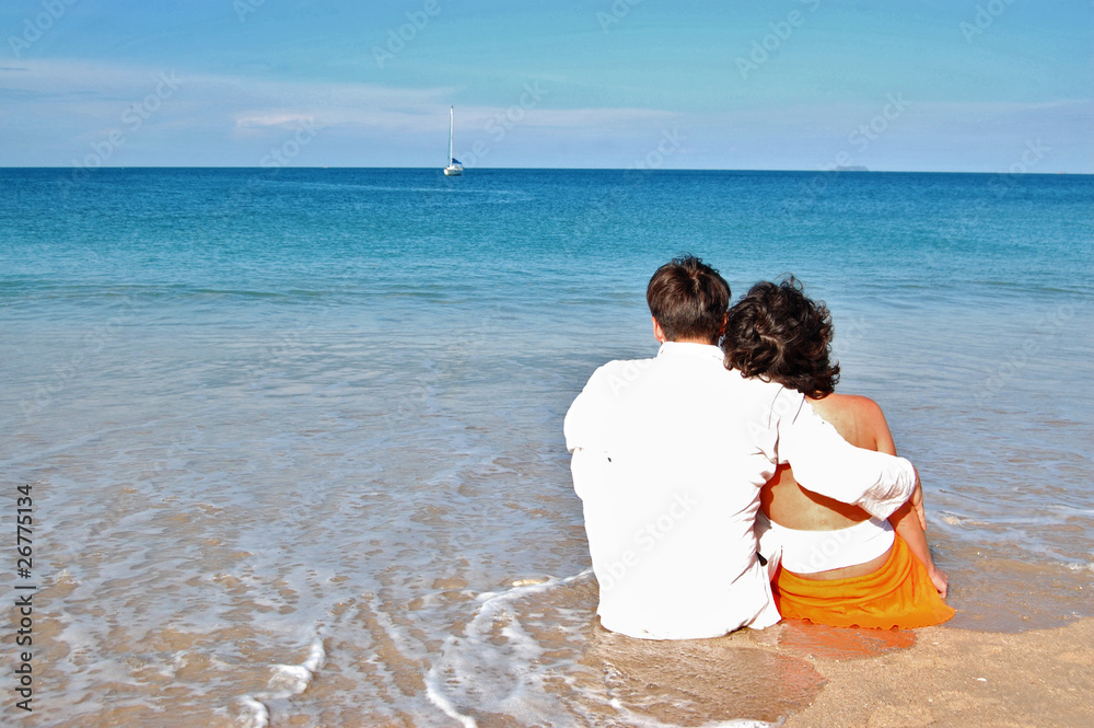 Romantic couple sitting on the tropical beach