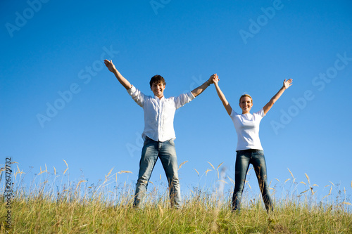 couple standing together with hands up on nature