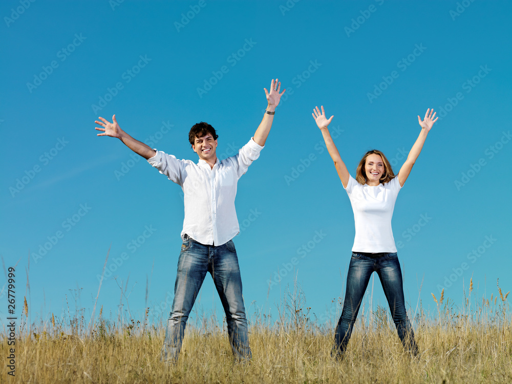 couple standing together with hands up outdoors couple standing together with hands up outdoors