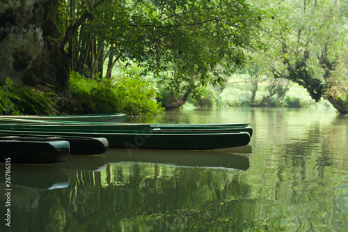 Boats anchored in shadow on river (1) photo