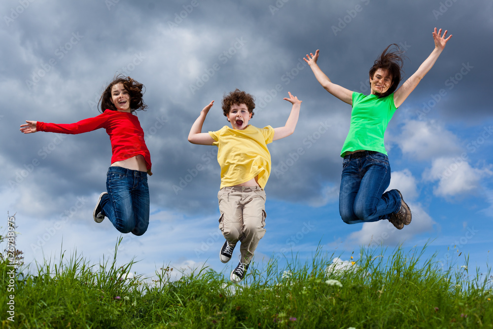 Active family - mother and kids jumping outdoor Active family - mother and kids jumping outdoor
