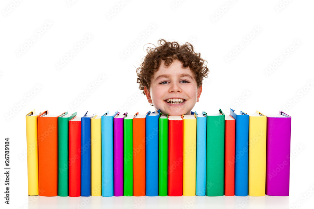 Boy sitting behind pile of books isolated on white Boy sitting behind pile of books isolated on white