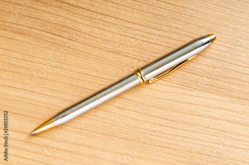 Writing silver pen on the wooden background