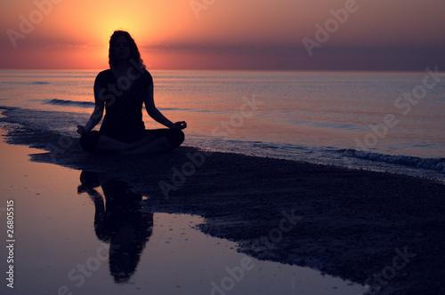 Woman doing yoga at sunset