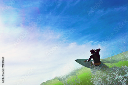 surfer hitting wave lip against beautiful blue skies