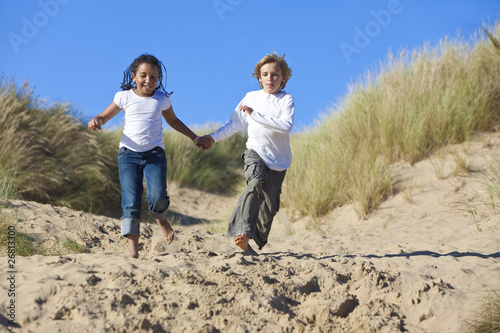 Blond Boy & Mixed Race Girl Running At Beach