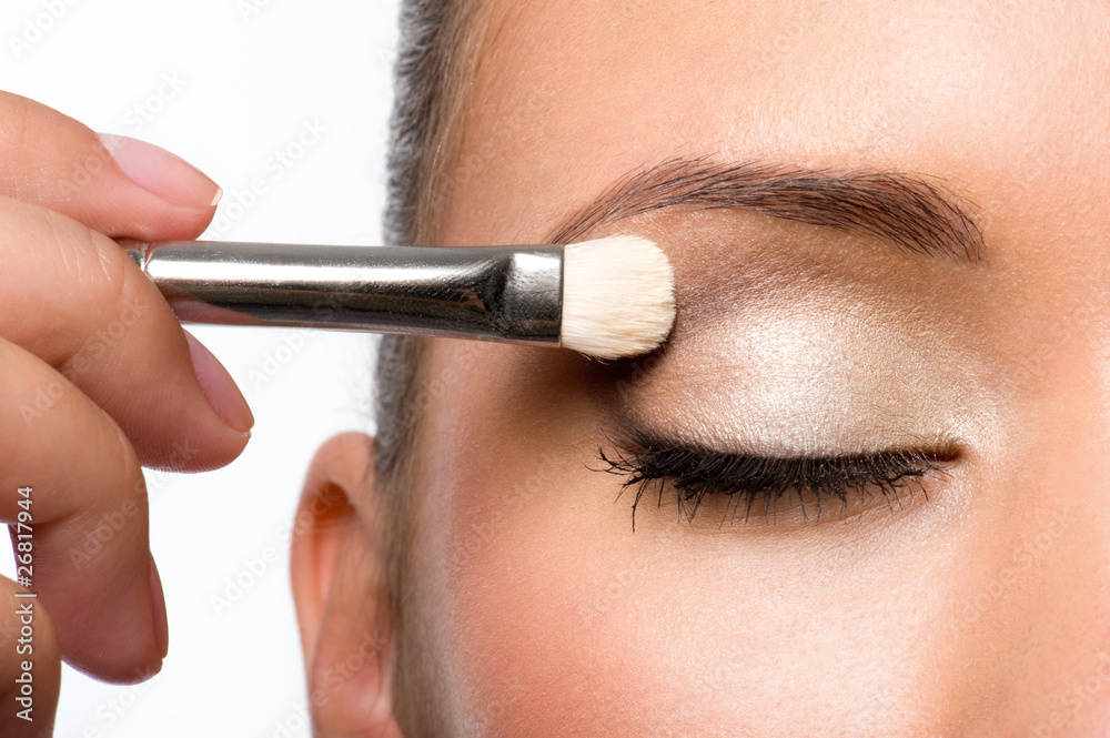 woman applying eyeshadow on eyelid
