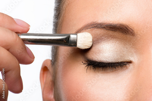 Foto woman applying eyeshadow on eyelid
