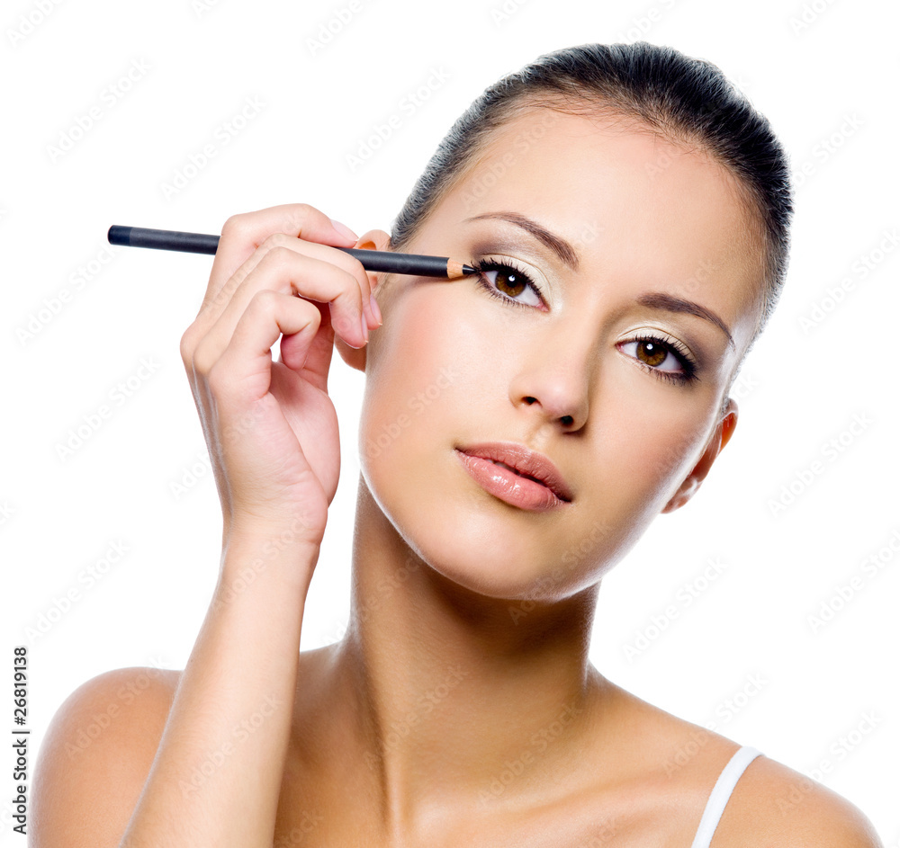 woman applying eyeliner on eyelid with pencil woman applying eyeliner on eyelid with pencil