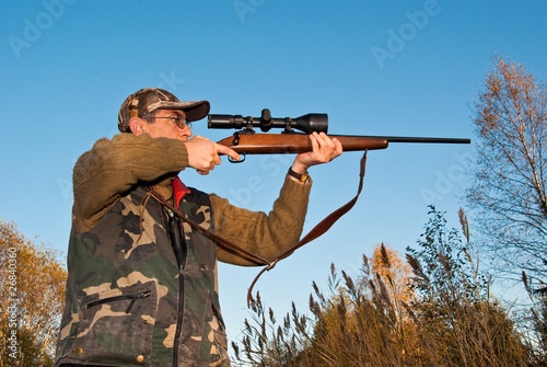 Hunter aiming animals with rifle sight
