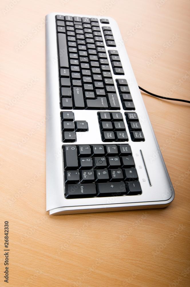 Computer keyboard on the wooden polished table