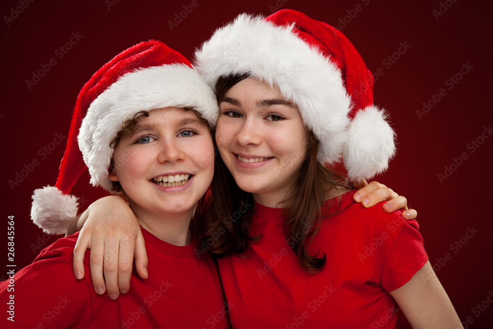 Christmas time - girl and boy with Santa Claus Hat Christmas time - girl and boy with Santa Claus Hat