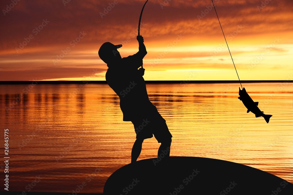fisherman with a catching fish on sunrise background - obrazy, fototapety, plakaty 