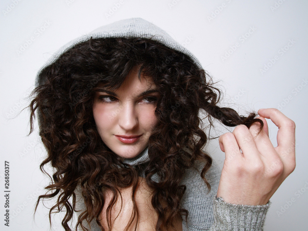 Young girl in hood playing with her hair