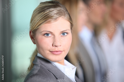 Businesswoman standing in front of group in the office