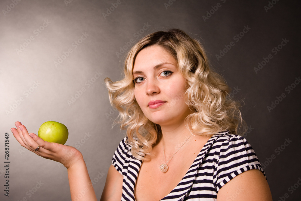 Portrait of beautiful young woman of blonde with a green apple Portrait of beautiful young woman of blonde with a green apple