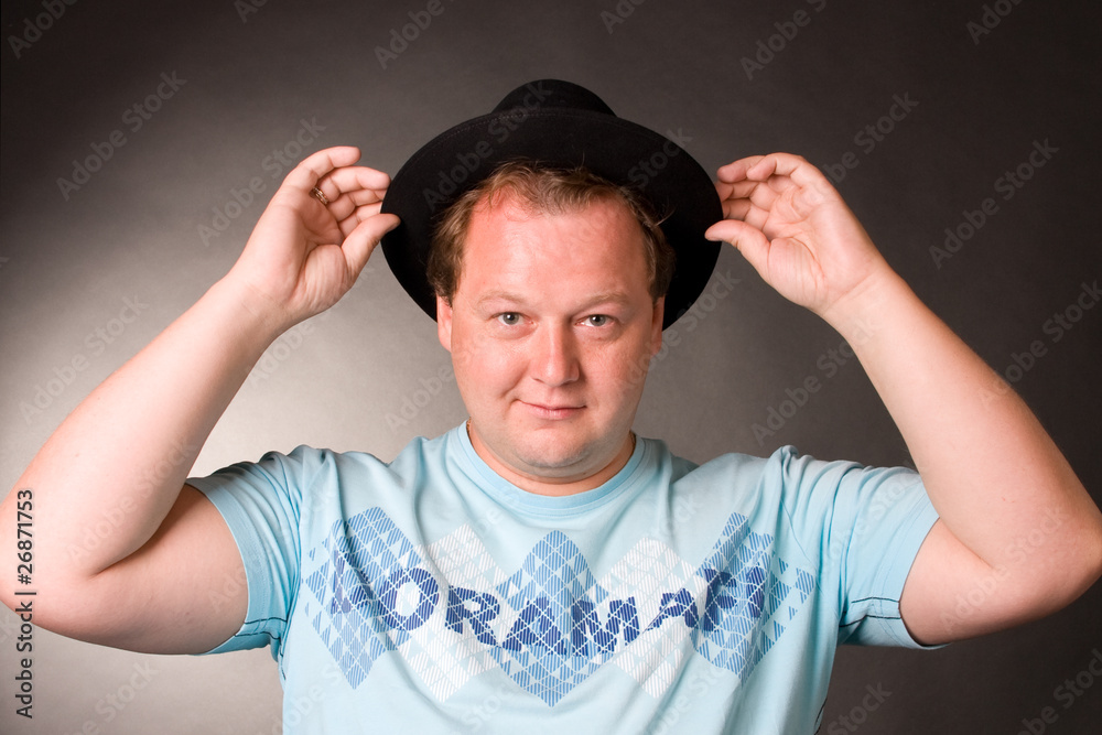 Attractive young man in a blue sport shirt and with a black hat