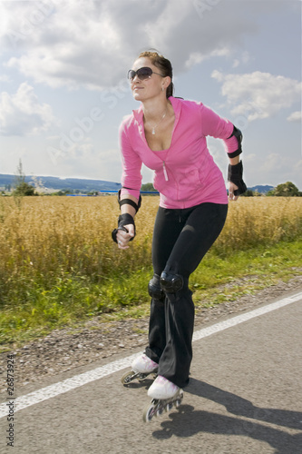 Beautiful young woman sports with roller-skates