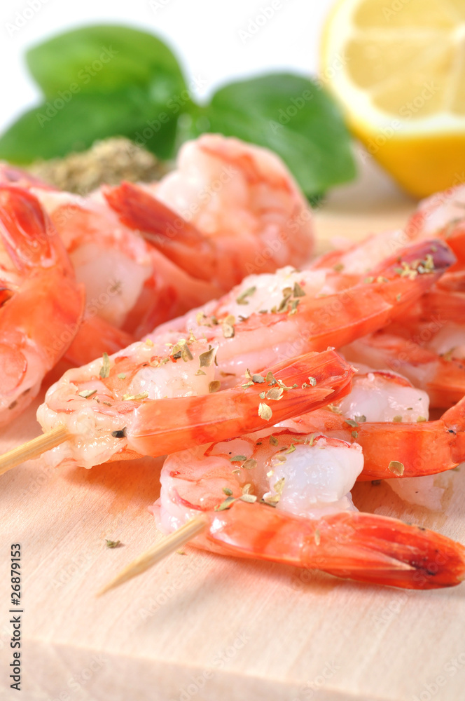 Shrimps, olives, lemon, and basil on board isolated on white bac Shrimps, olives, lemon, and basil on board isolated on white bac