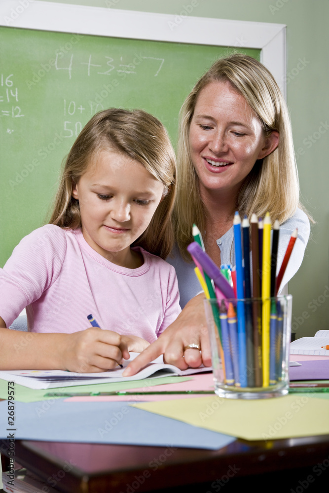 Teacher and young student in class writing Teacher and young student in class writing