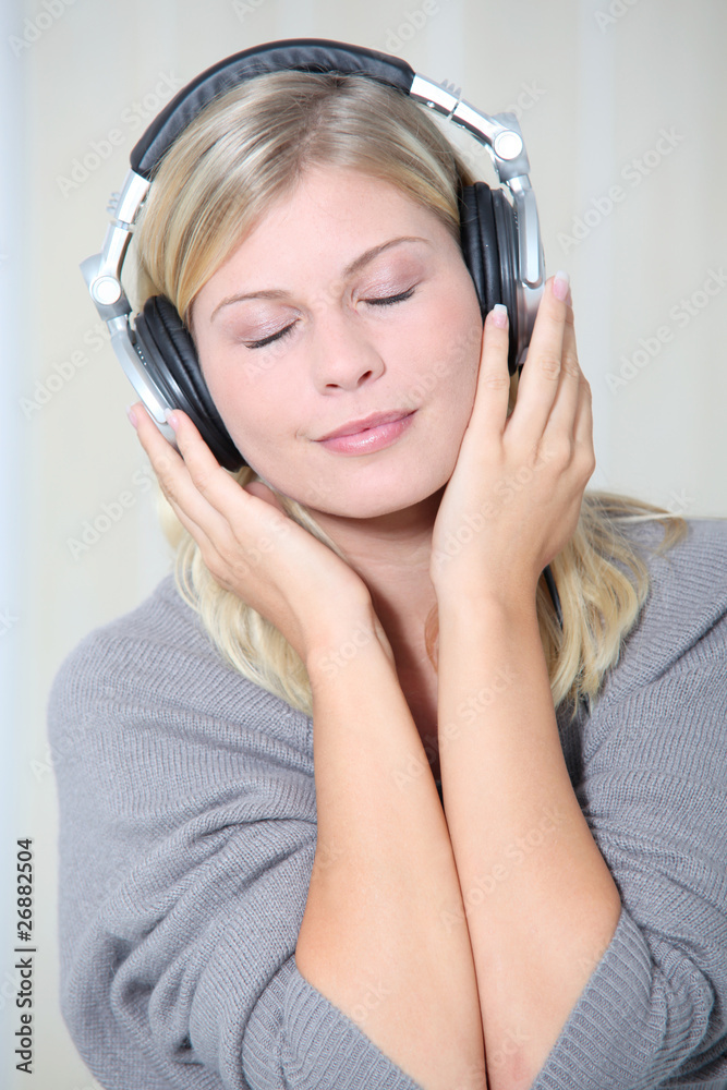 Beautiful blond woman at home with headphones on Beautiful blond woman at home with headphones on