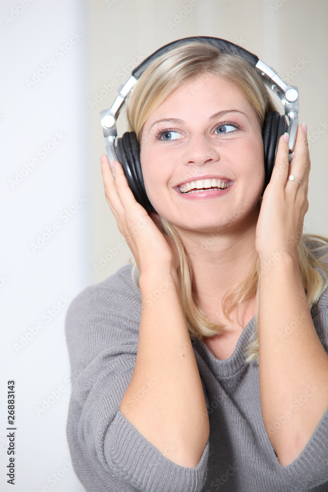 Beautiful blond woman at home with headphones on Beautiful blond woman at home with headphones on