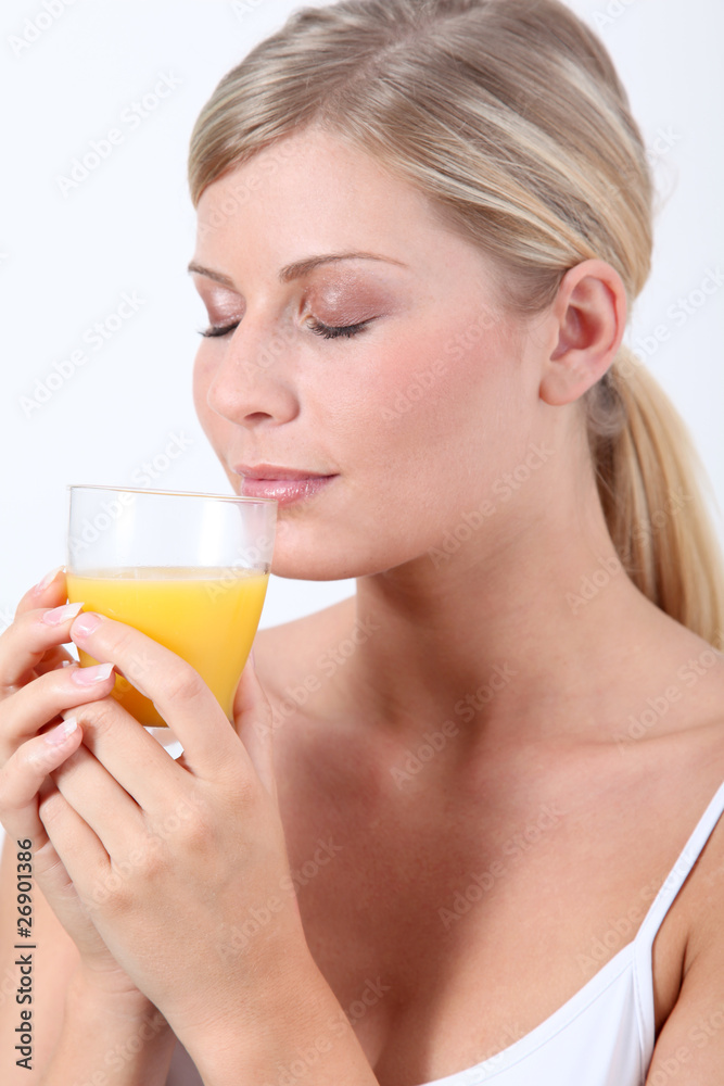 Beautiful blond woman holding glass of orange juice Beautiful blond woman holding glass of orange juice