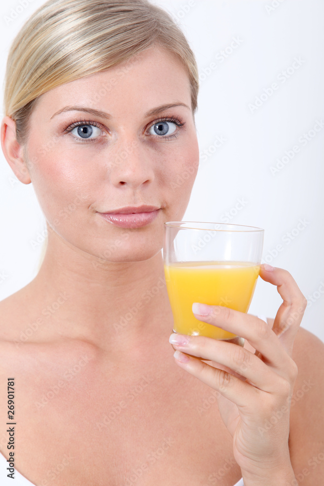 Beautiful blond woman holding glass of orange juice Beautiful blond woman holding glass of orange juice
