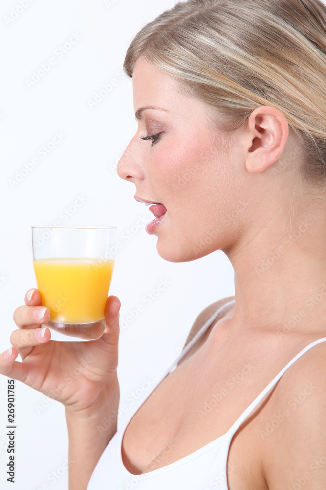 Beautiful blond woman holding glass of orange juice Beautiful blond woman holding glass of orange juice