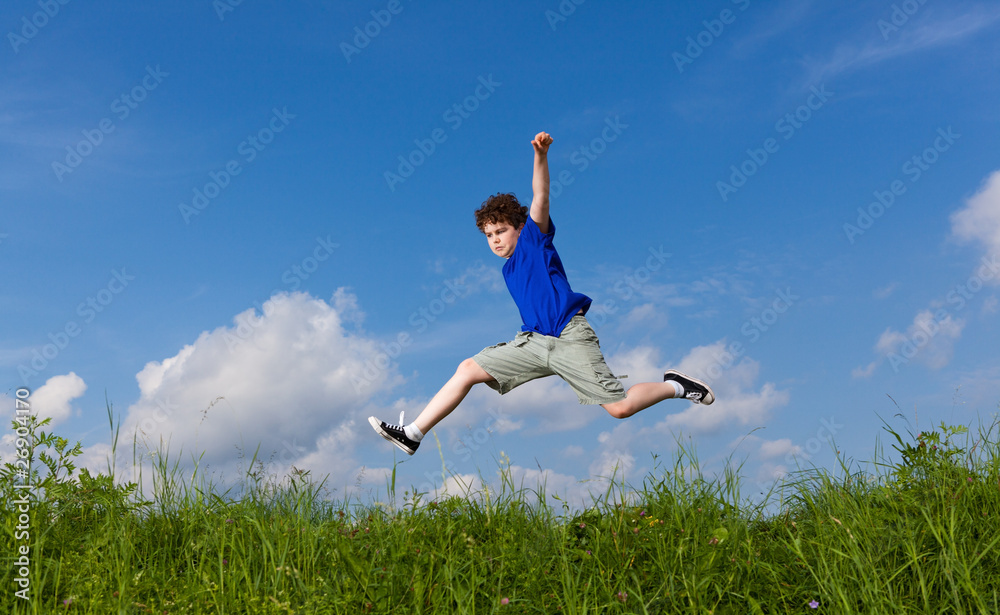 Boy jumping, running against blue sky Boy jumping, running against blue sky