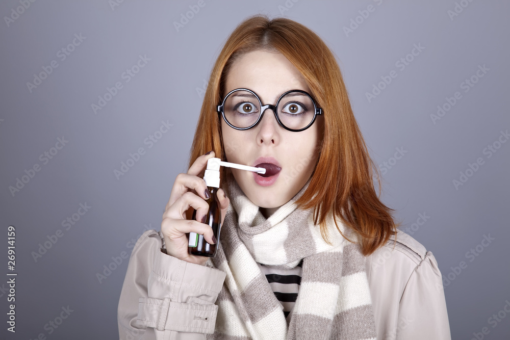 Chill red-haired girl in glasses and scarf with spray.