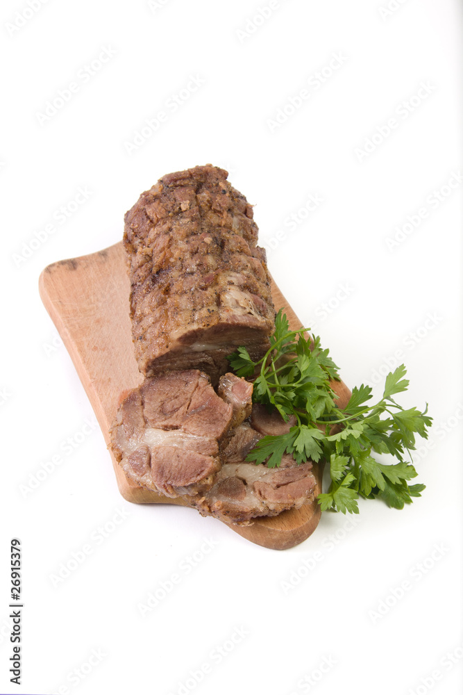 Appetizing piece of roasted meat on a wood piece with parsley