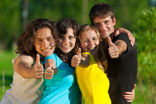 Young group of happy friends showing thumbs up sign