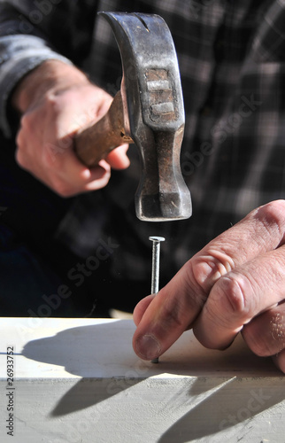 Hand holding a Hammer and Nail