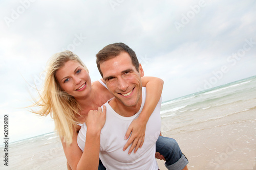 Happy couple enjoying vacation on a sandy beach © goodluz