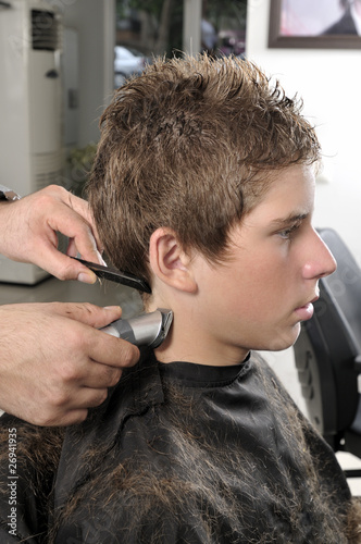 Professional hairdresser cut hair with clipper at saloon.