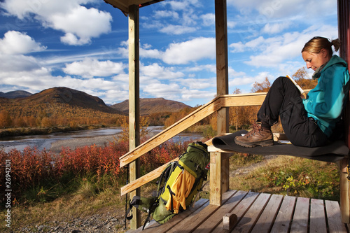Wanderin macht vor einer Hütte eine Pause