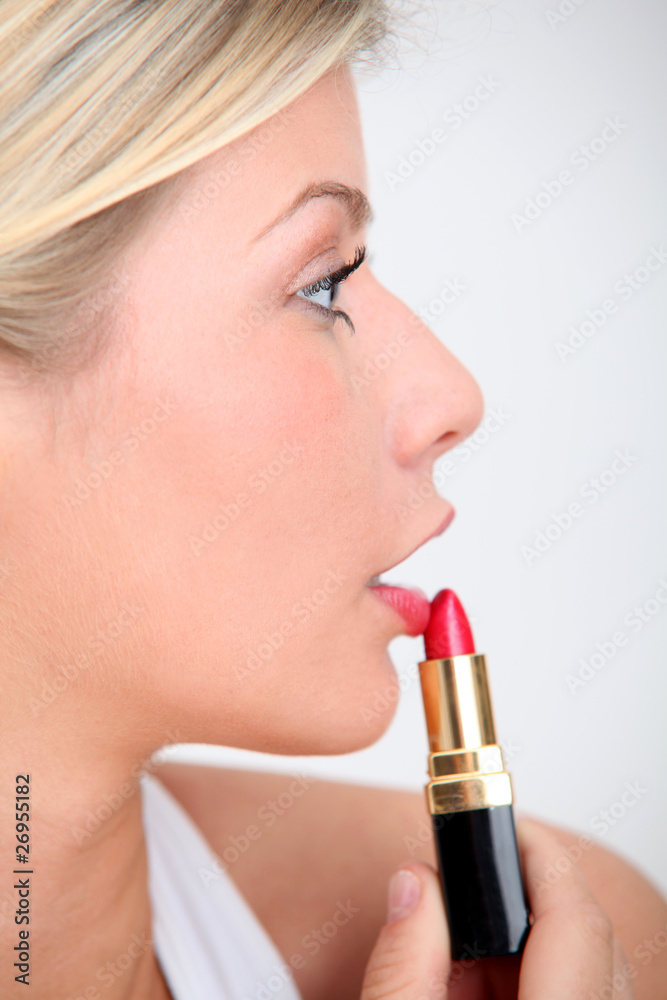Blond woman putting makeup on