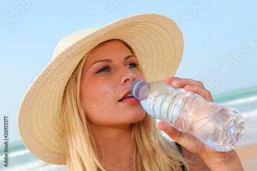Closeup of woman drinking water at the beach