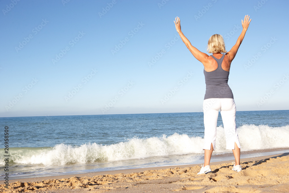 Senior Woman In Fitness Clothing Stretching On Beach Senior Woman In Fitness Clothing Stretching On Beach