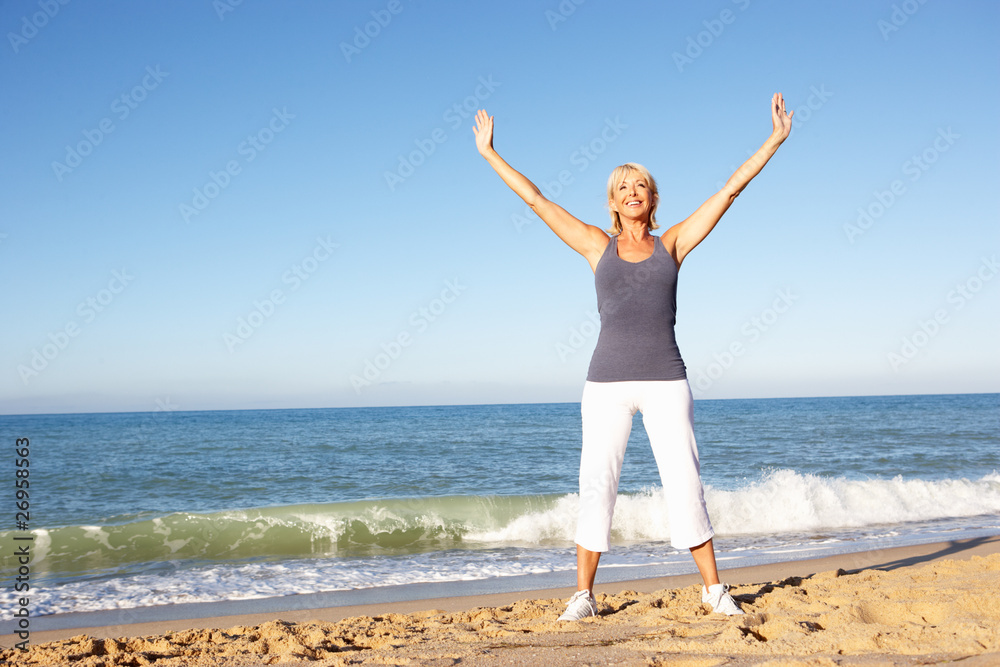 Senior Woman In Fitness Clothing Stretching On Beach Senior Woman In Fitness Clothing Stretching On Beach