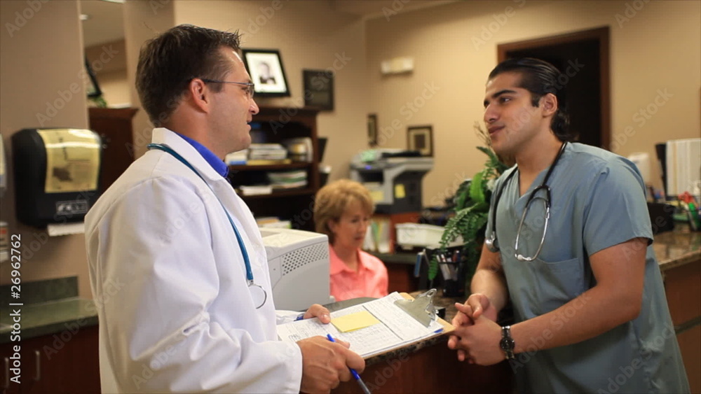 Young doctors stop talking and smile for the camera. Young doctors stop talking and smile for the camera.