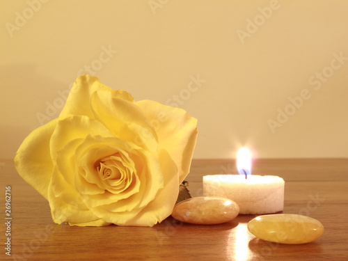 Kerze neben gelber Rose