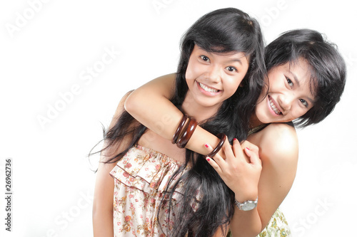 Two girl best friends smiling over white background