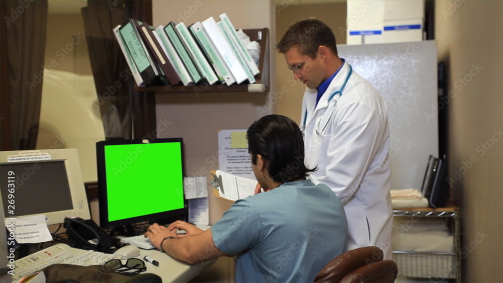 Health care providers at computer smile for camera. Health care providers at computer smile for camera.