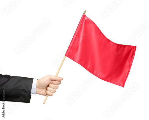 Obraz na plátně Hand holding a red flag